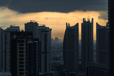Skyscrapers against sky during sunset