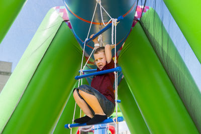 Low angle portrait of boy on rope ladder