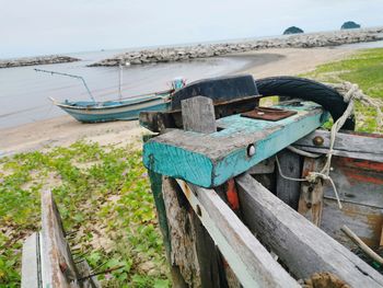 Close-up of boats moored on beach against sky