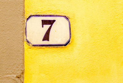 Close-up of number 7 on yellow wall