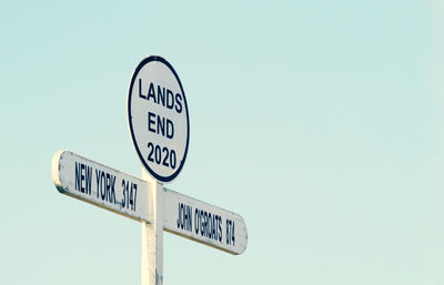 Low angle view of road sign against clear sky