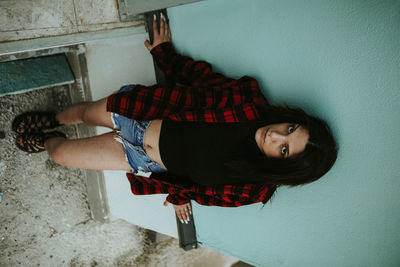 Portrait of young woman against wall at home