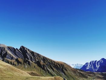 Scenic view of mountains against clear blue sky