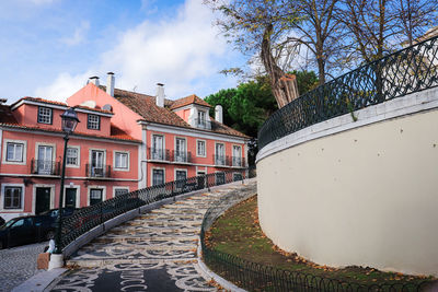 Footpath amidst houses and buildings against sky