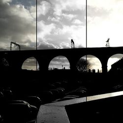 Bridge over river against cloudy sky
