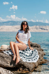 Portrait of beautiful young woman in beach clothes sunbathing on summer vacation.