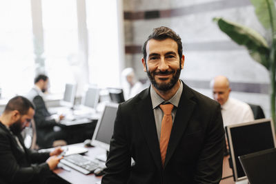 Portrait of smiling bearded male financial advisor in law office