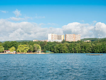 Scenic view of sea by buildings against sky