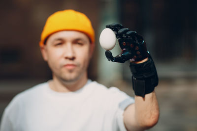 Man with prosthetic arm holding egg