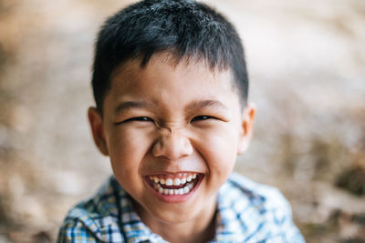 Close-up portrait of cheerful boy standing outdoors