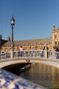 View of canal and buildings against blue sky