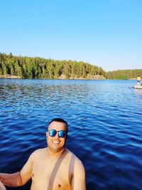 Portrait of man in swimming pool against clear blue sky