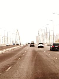 Cars on road in city against clear sky