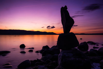 Purple sunset lake constance with stones on the lake shore