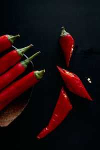 Close-up of red chili peppers on table against black background