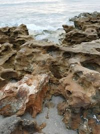 Close-up of rocks on beach against sky