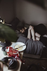 High angle view of sad woman lying on bed