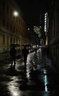 Wet street amidst buildings in city during rainy season