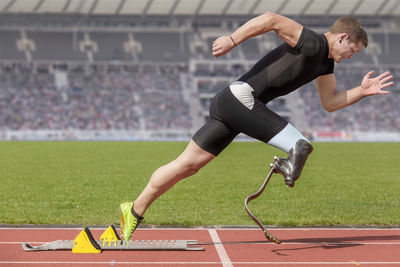 Male athlete with amputated leg on running on track