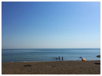 Scenic view of beach against clear blue sky