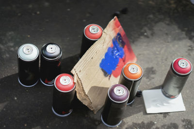 High angle view of aerosol cans on wet road 