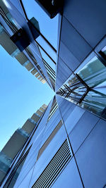 Low angle view of modern building against clear blue sky