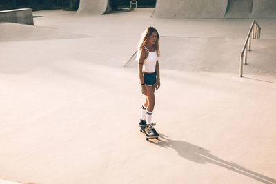 High angle view of woman standing on skateboard outdoors