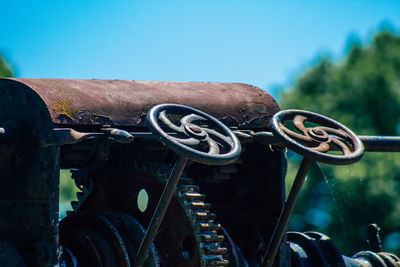 Close-up of rusty wheel against sky