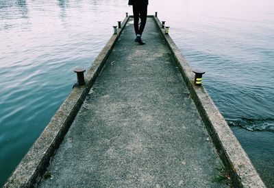 Low section of man walking on pier