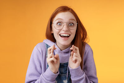 Portrait of a smiling young man against yellow background