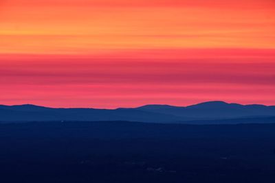 Scenic view of silhouette mountains against romantic sky at sunset