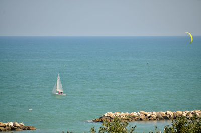 Sailboat in sea against clear sky