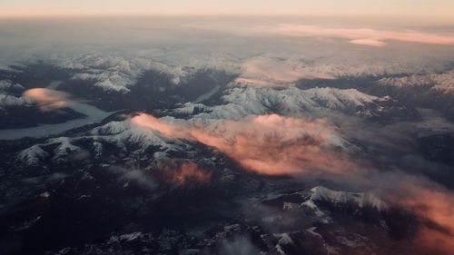 Aerial view of snowcapped mountains at sunset over switzerland
