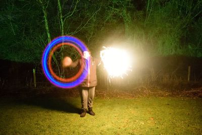 View of person holding illuminated lighting equipment at night