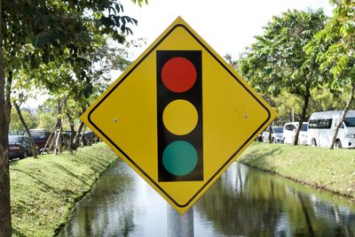 Close-up of road sign against canal