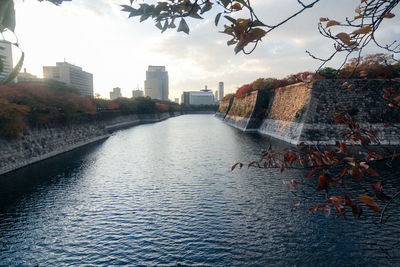 River amidst buildings in city against sky