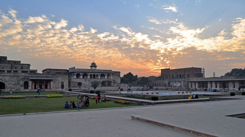 People in city against sky during sunset