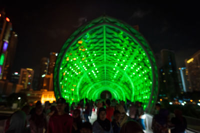 People enjoying illuminated music concert at night