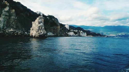 Scenic view of sea and mountains against sky