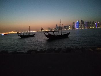 Boats in harbor at sunset