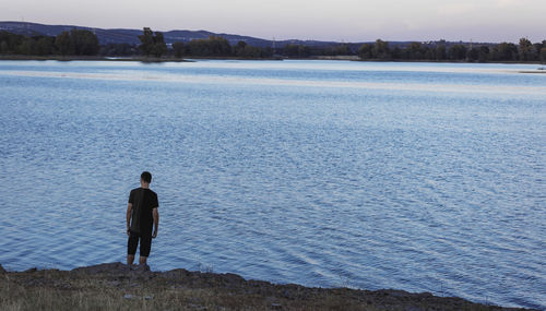 Rear view of man looking at lake