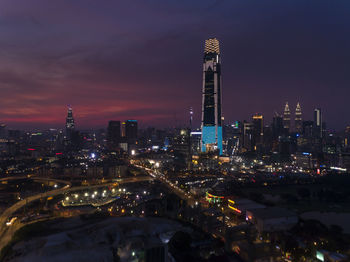 Illuminated buildings in city against sky at night