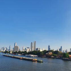 Scenic view of river and buildings against clear sky