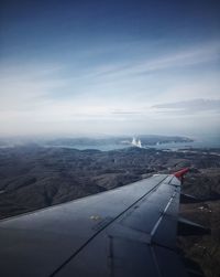 Airplane flying over mountains against sky