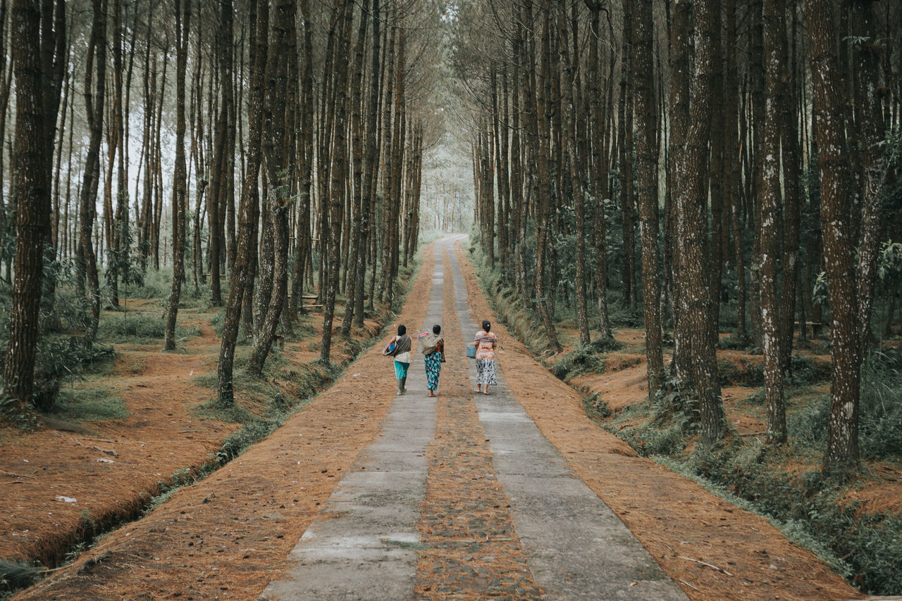 REAR VIEW OF TWO PEOPLE WALKING ON FOOTPATH