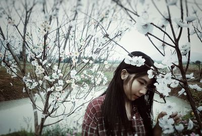 Girl looking at white cherry blossom flowers