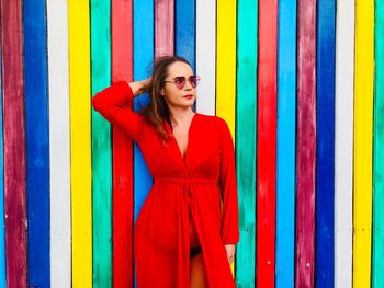 Woman in dress standing against multi colored wall