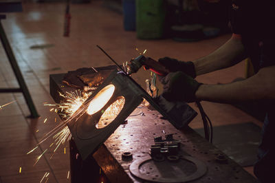 Cropped hand of man welding metal