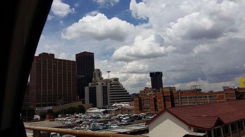 View of cityscape against cloudy sky