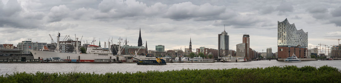 Buildings in city against cloudy sky